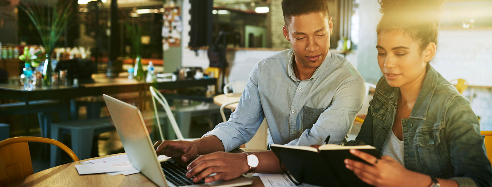 Business partners sitting at laptop going over expenses.