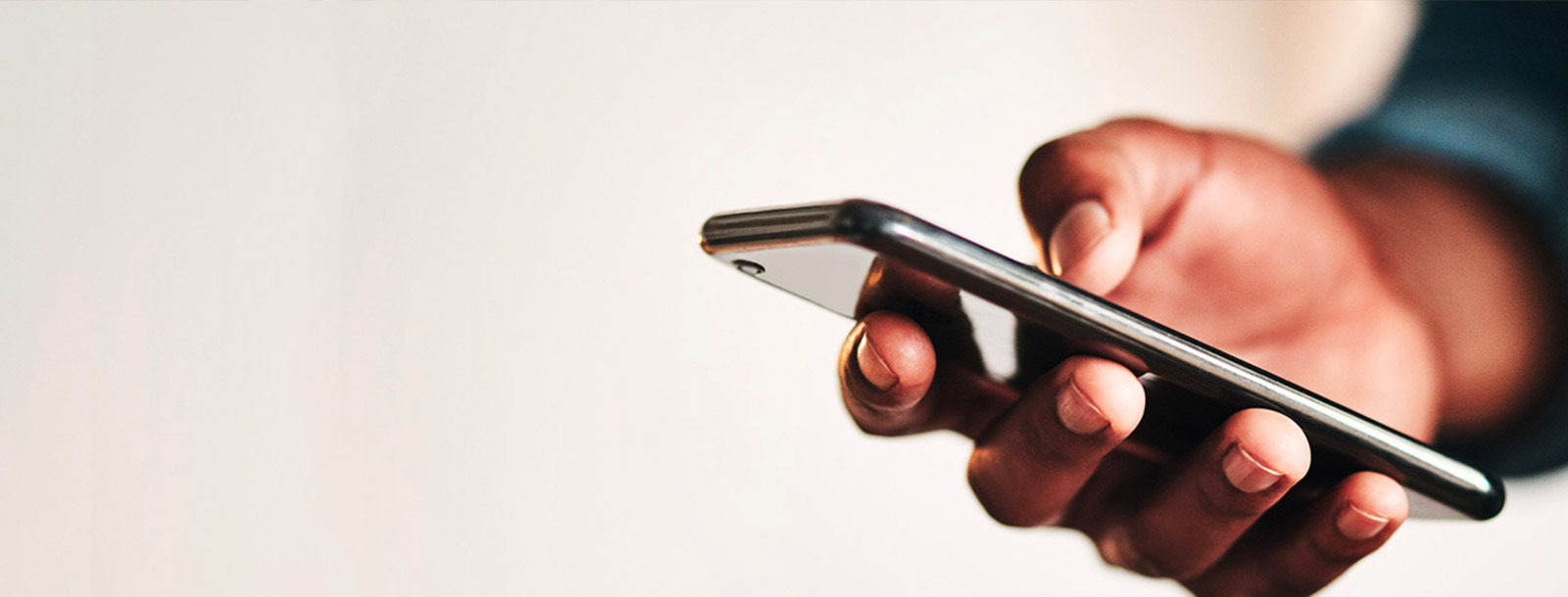 Hand holding a phone while banking.